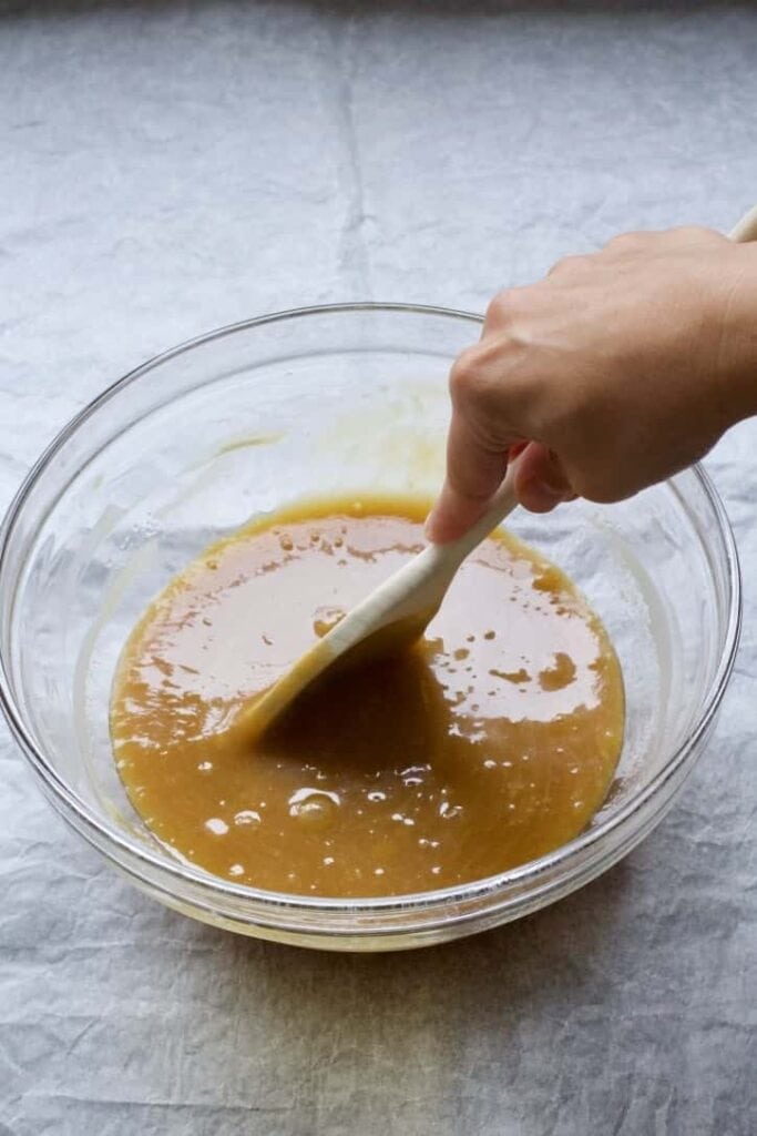 Ingredients are being mixed with a wooden spoon.