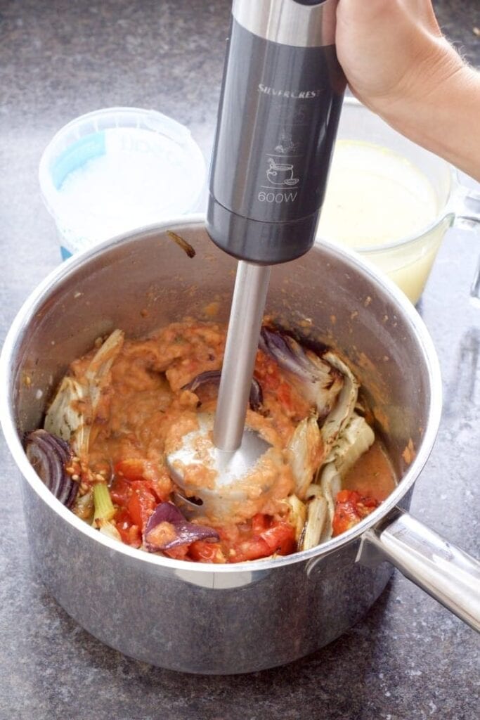 Vegetables being pureed with stick blender.