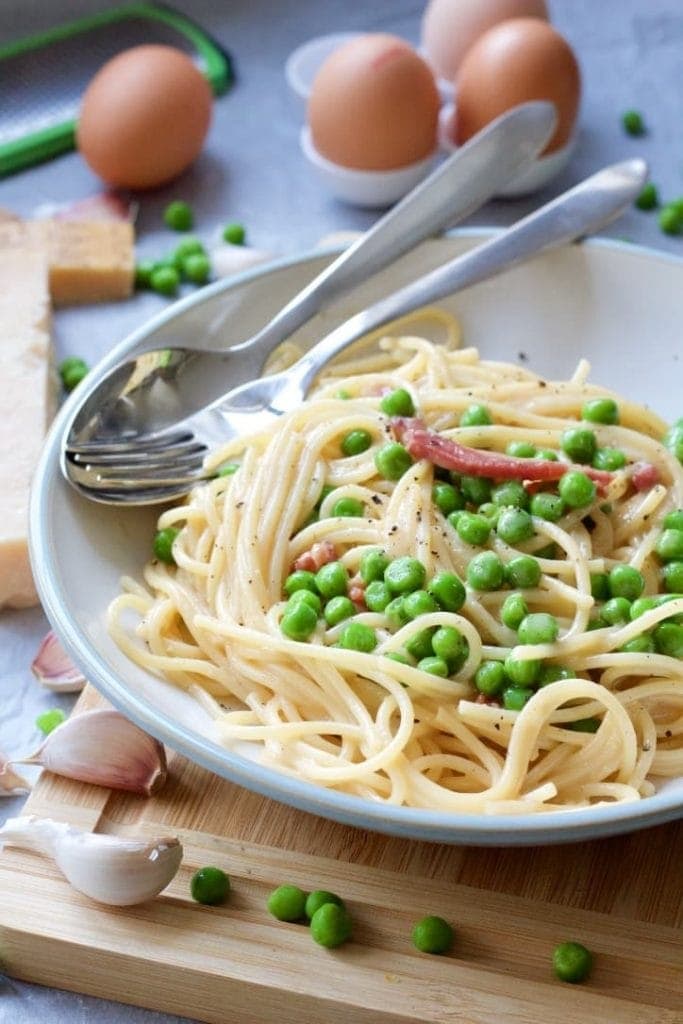 Spaghetti carbonara plated up with cutlery.