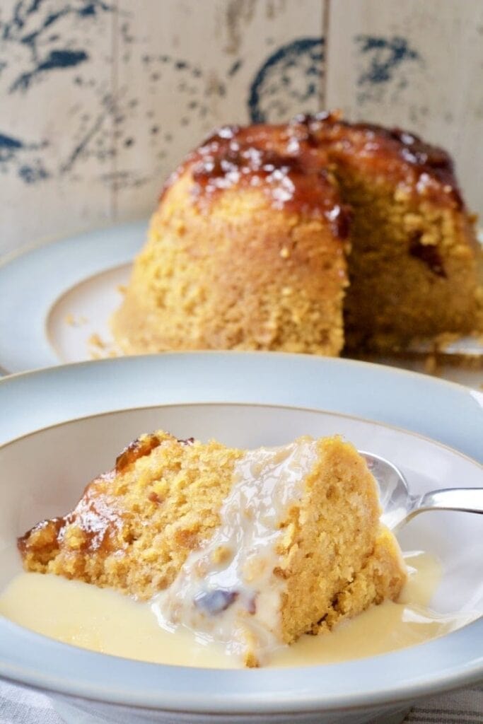 Steamed pudding served in a bowl with custard.