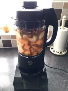 Ingredients for soup in a blender with lid on.