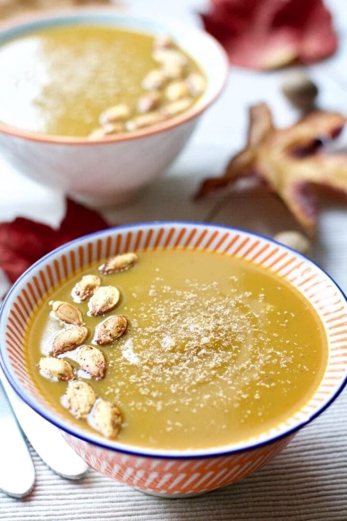 Close up of bowl with Butternut Squash & Chestnut Soup with pumpkin seeds on top.