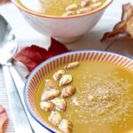 Butternut Squash & Chestnut Soup in a bowl with pumpkin seeds on top.