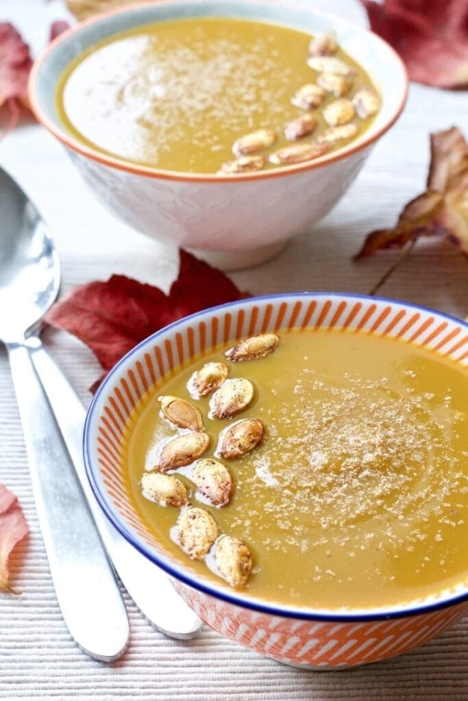 Butternut Squash & Chestnut Soup in a bowl with pumpkin seeds on top.
