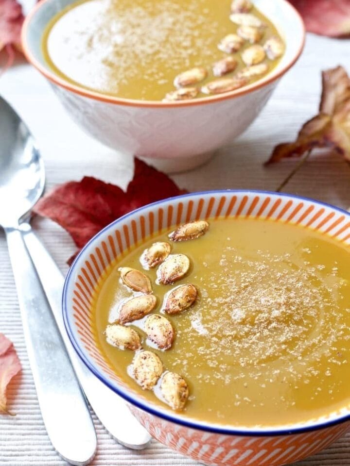 Butternut Squash & Chestnut Soup in a bowl with pumpkin seeds on top.