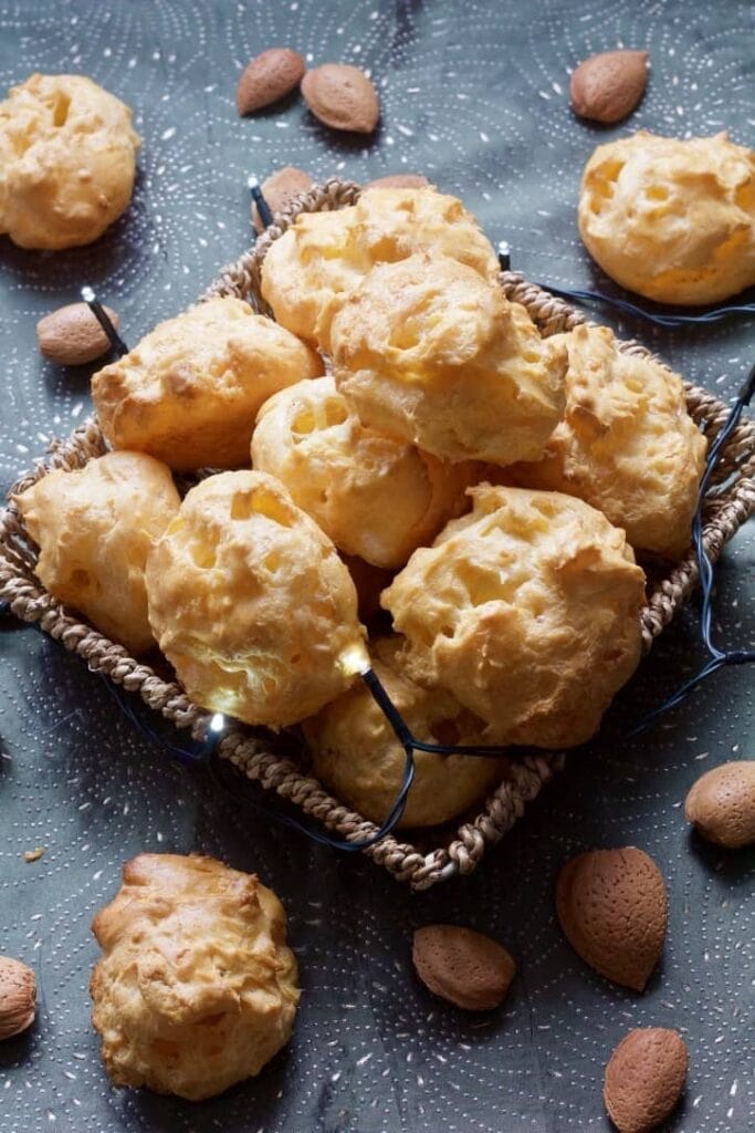 Gougeres in a basket with almonds and lights around.