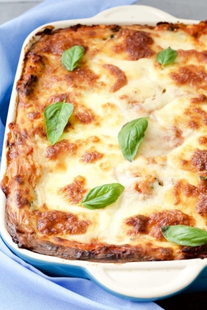 Lentil and Spinach Lasagne in a dish with basil leaves.