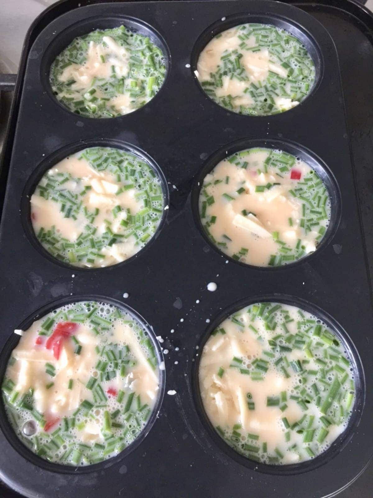 Egg muffin mixture in muffin tin.