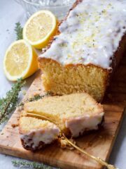 Vegan Lemon Drizzle Cake on a board with slice being cut with a fork.