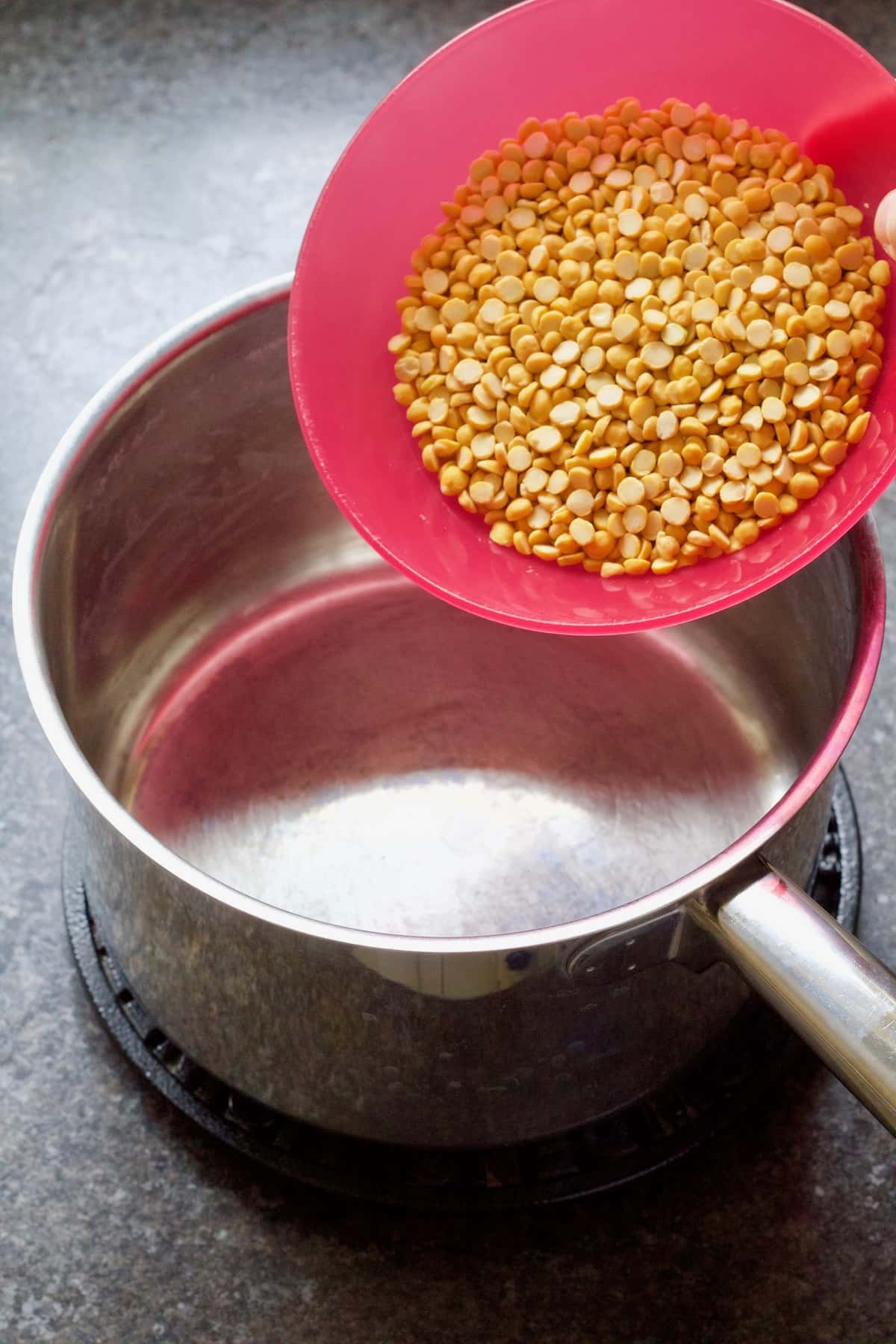 Rinsed chana dhal being added to the pan.