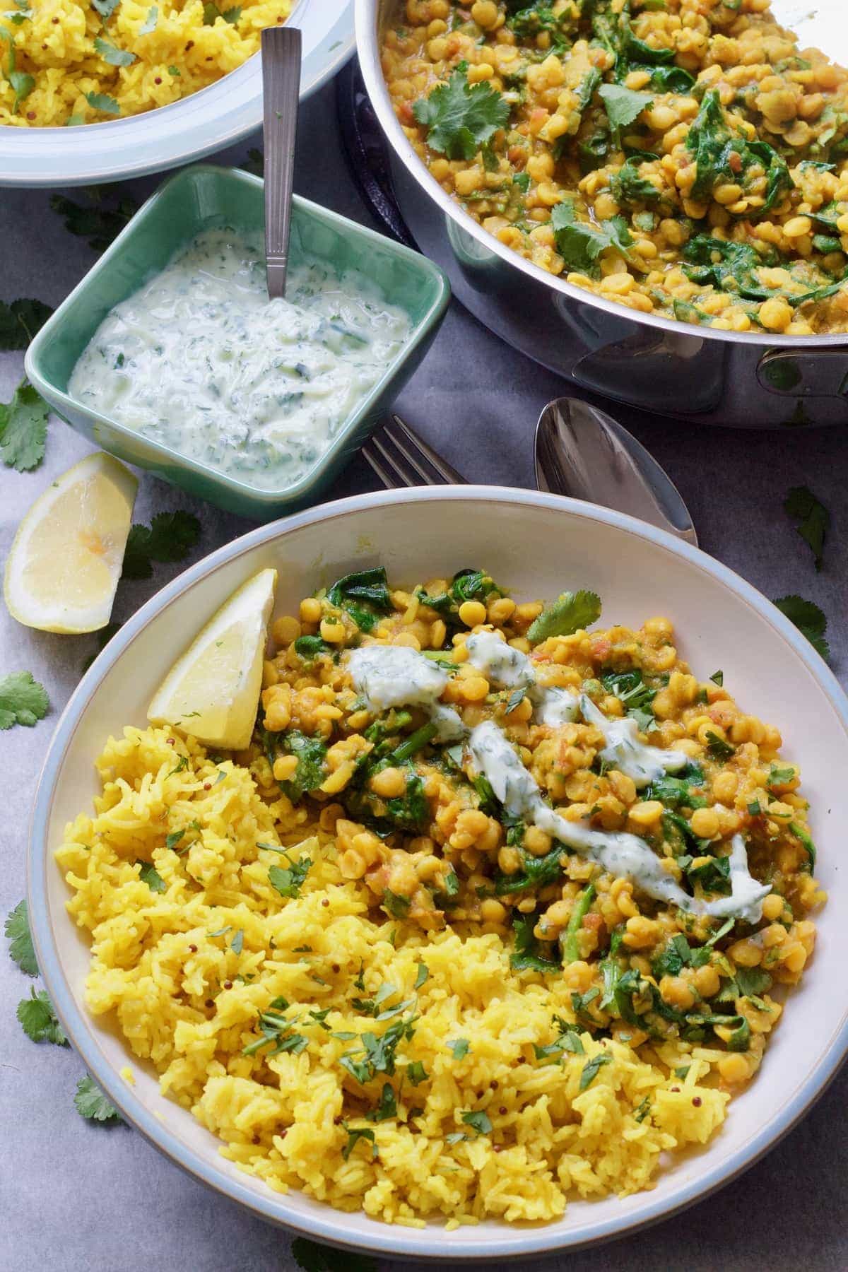 Bowl of dhal with raita drizzle with rice & raita on the side.