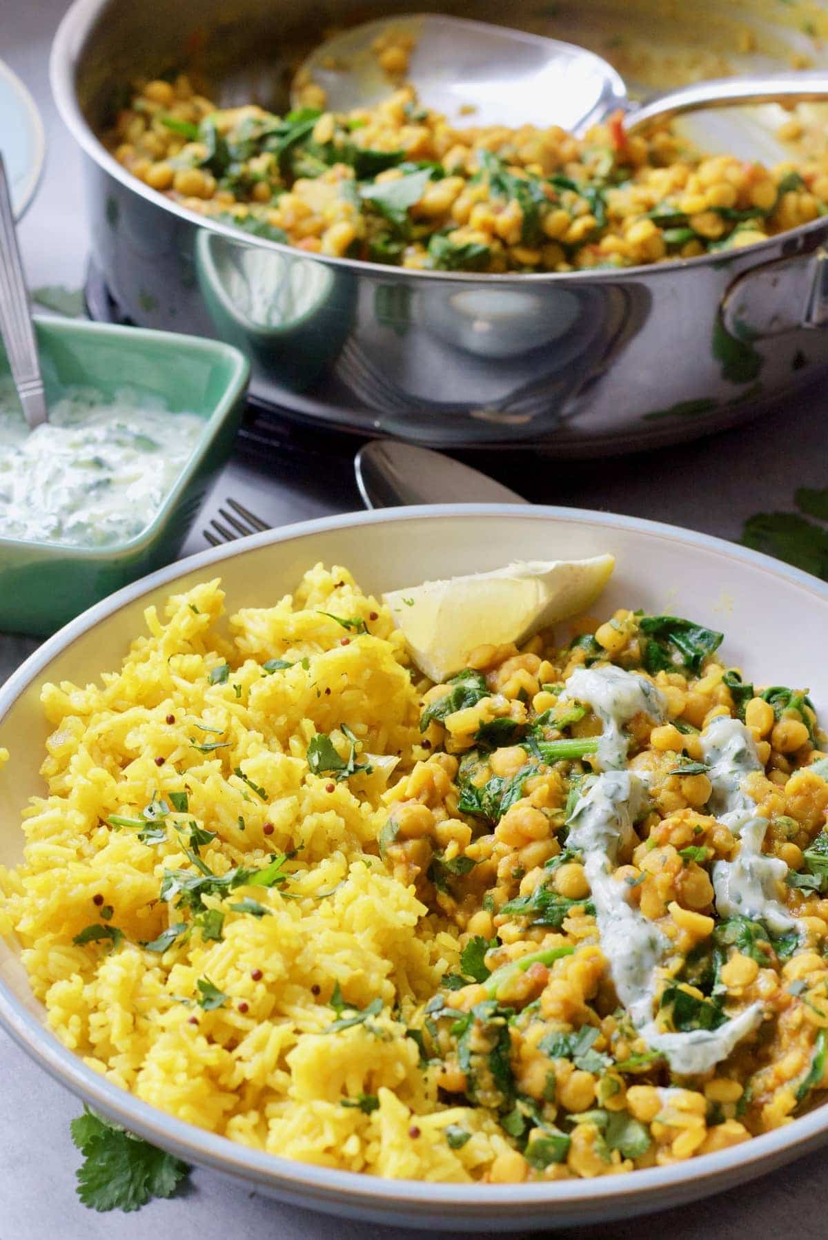 Bowl of dhal with rice with lemon wedge.