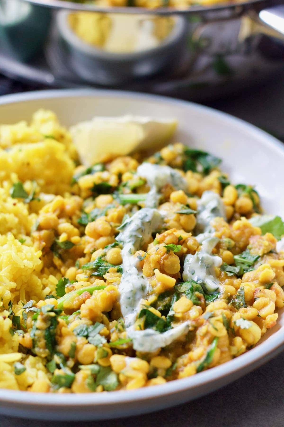 Plated portion of Tarka Dhal with drizzle of raita.