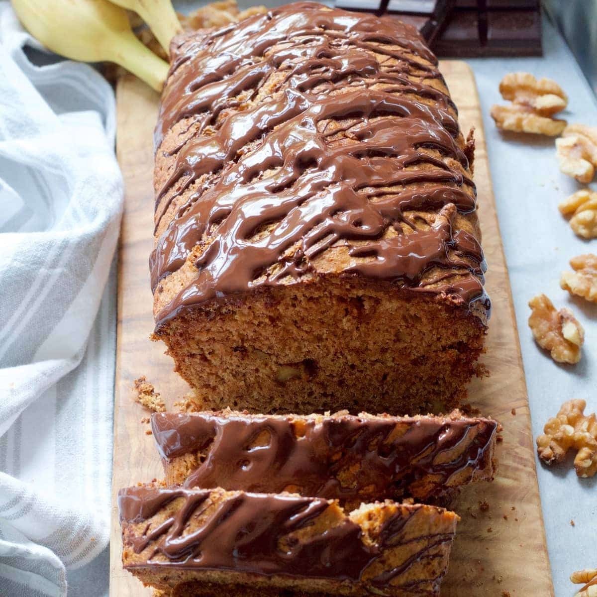 Healthy Vegan Banana Bread on the board with two slices cut off.