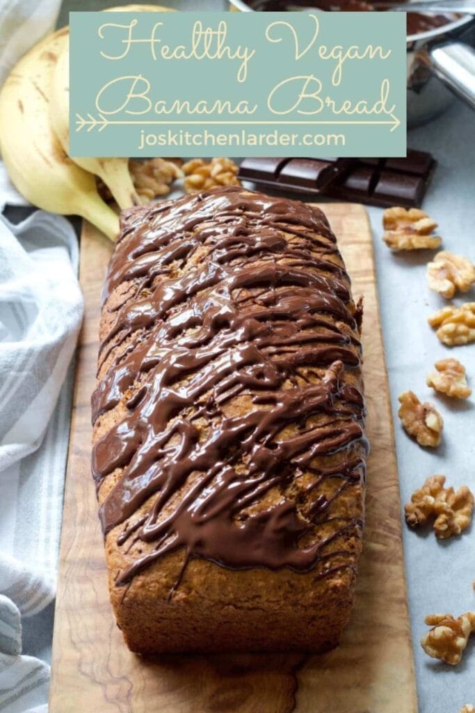 Healthy Vegan Banana Bread loaf drizzled with chocolate.