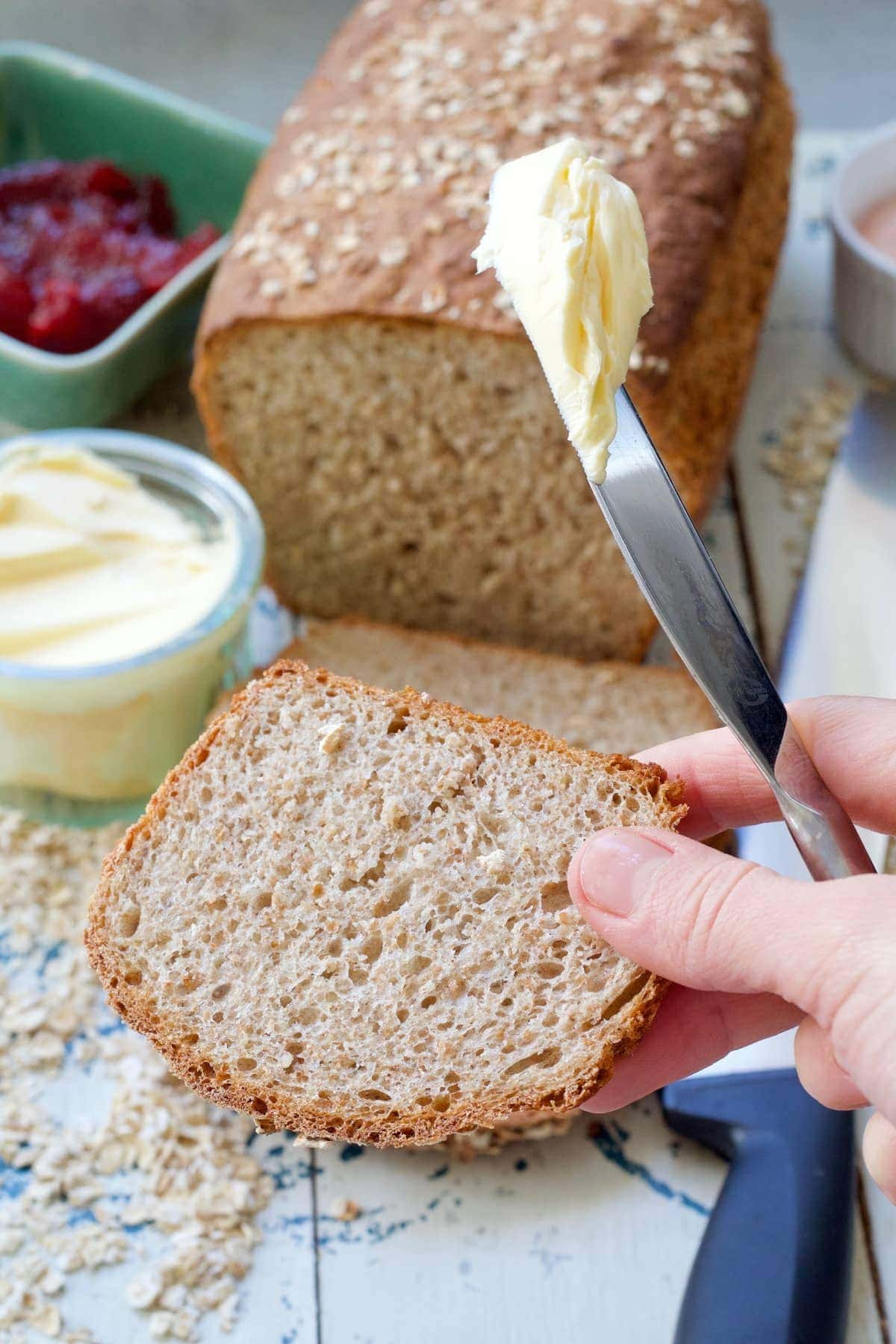 End bit of bread in hand about to be buttered.