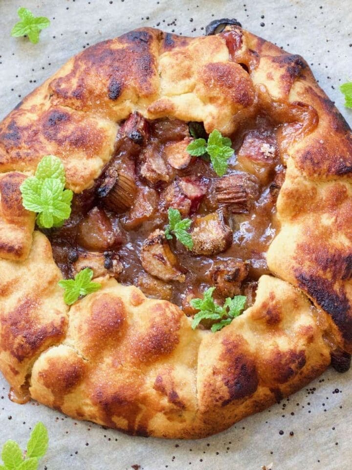 Rhubarb tart on baking tray with mint garnish.