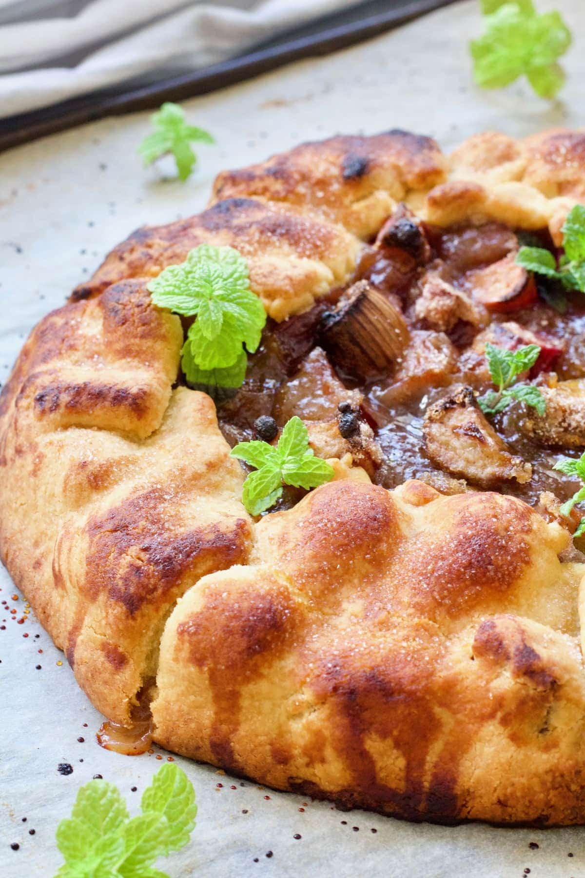 Close up of half of a rustic tart with mint garnish.