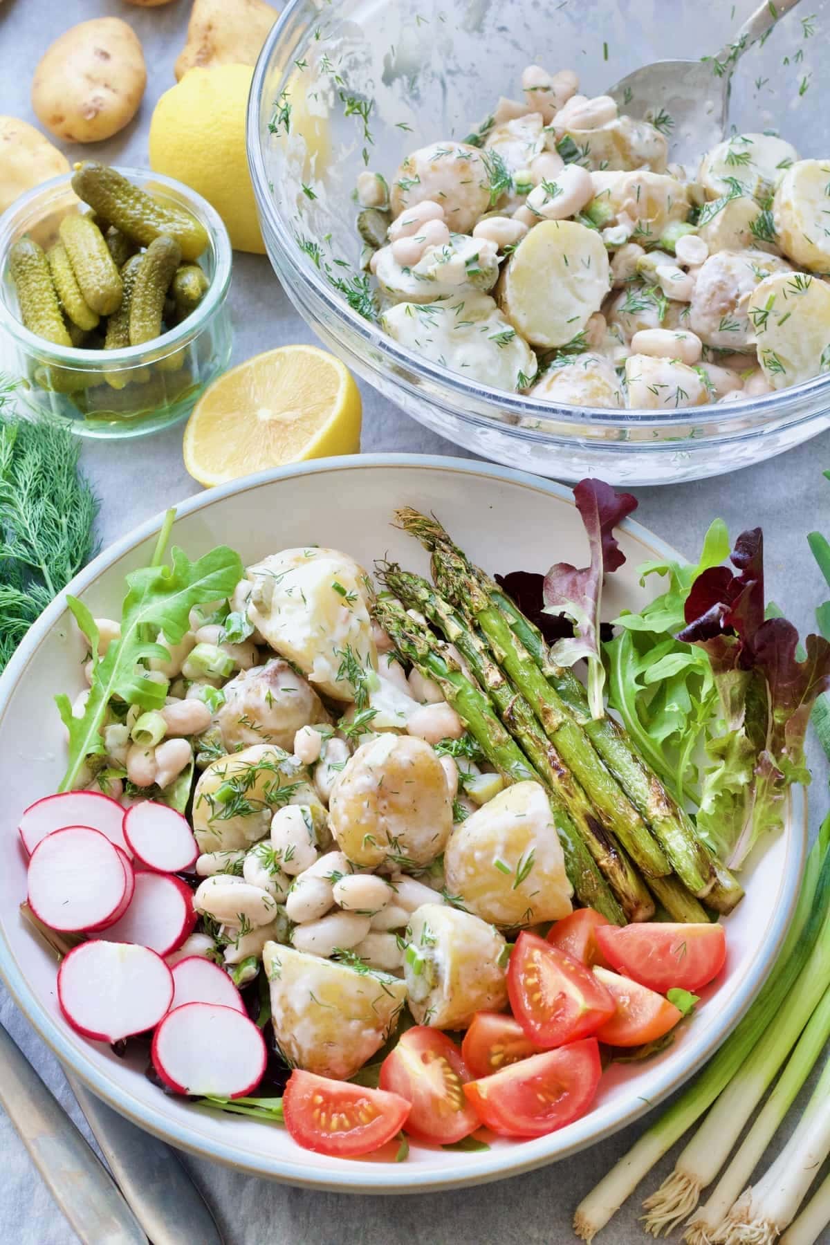 Potato salad on a plate with other veggies.