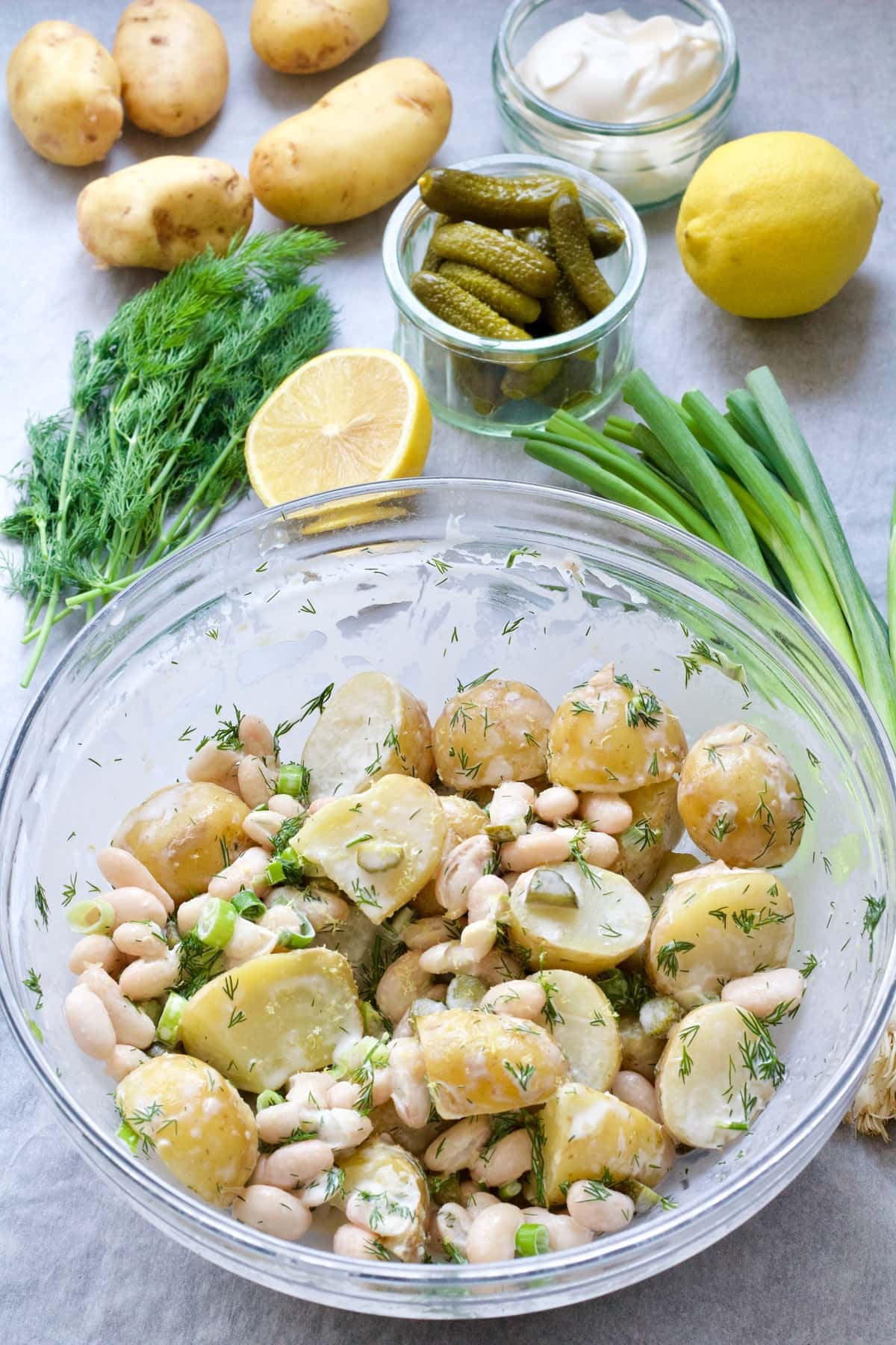 Bowl with potato salad and ingredients around it.