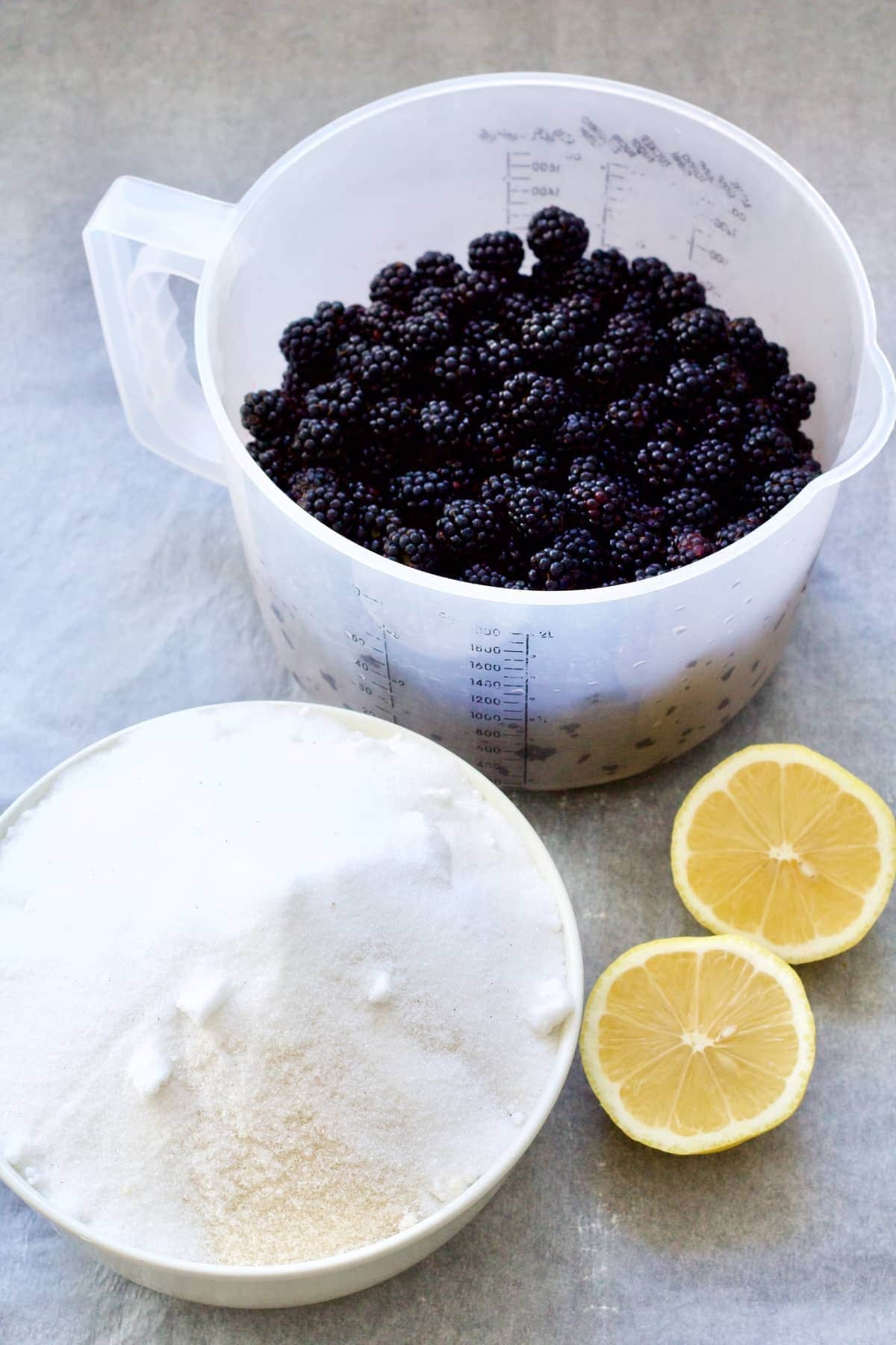 Blackberries, sugar and lemon cut in half.