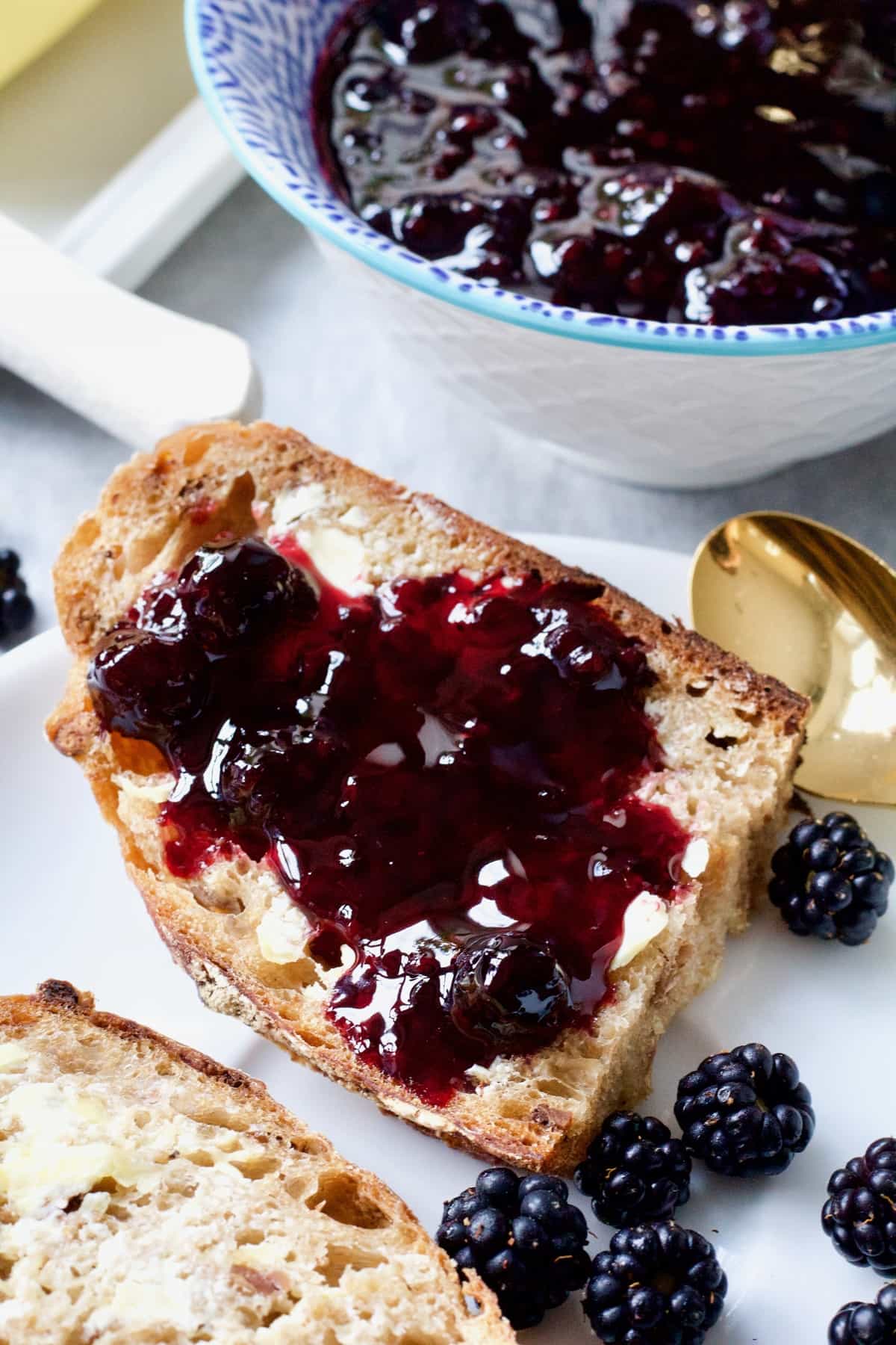 Half a slice of bread with blackberry jam on it.