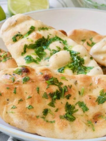 Close up of cooked easy naan bread with coriander and garlic butter.