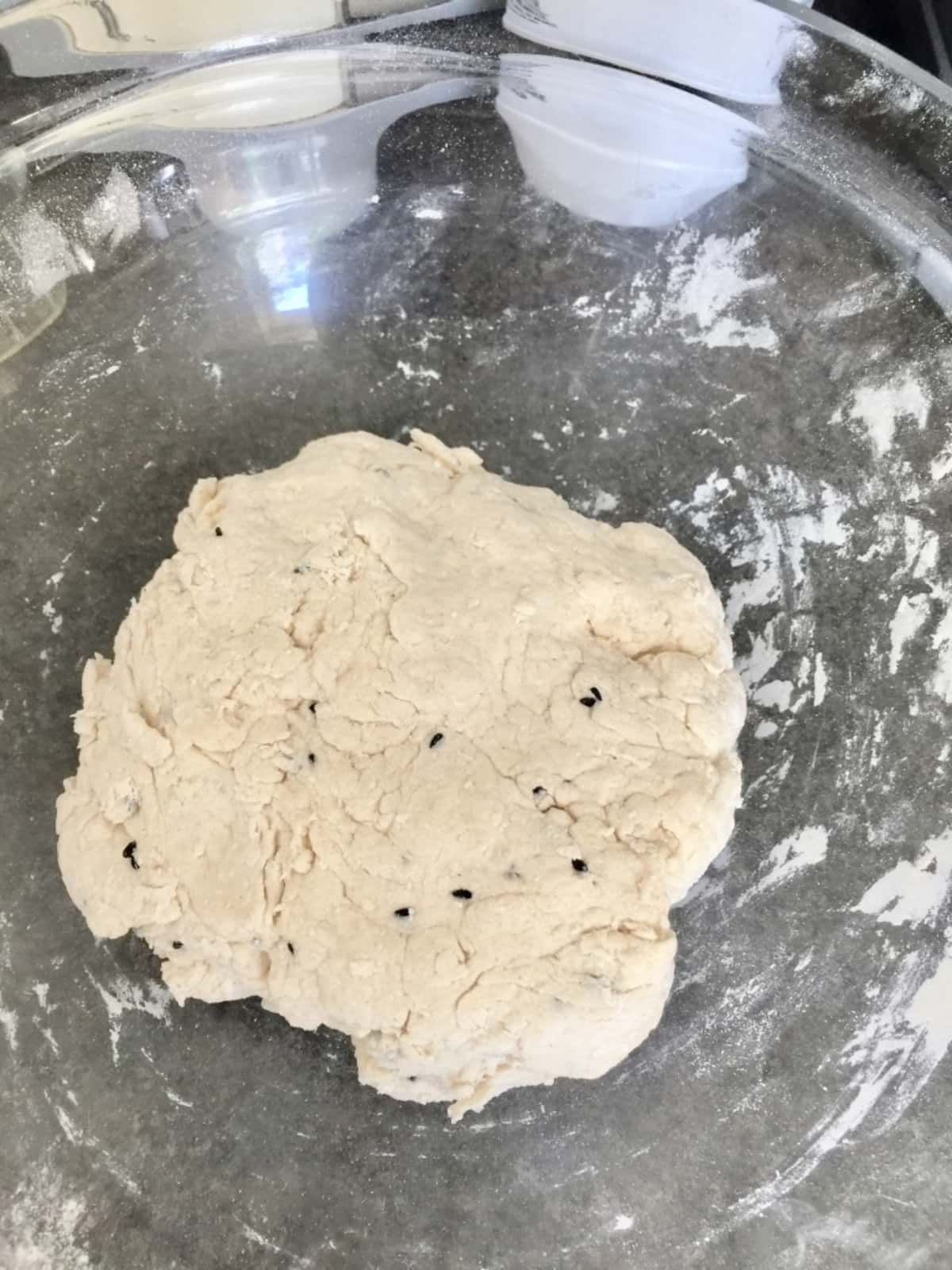Large ball of naan bread dough in a bowl.