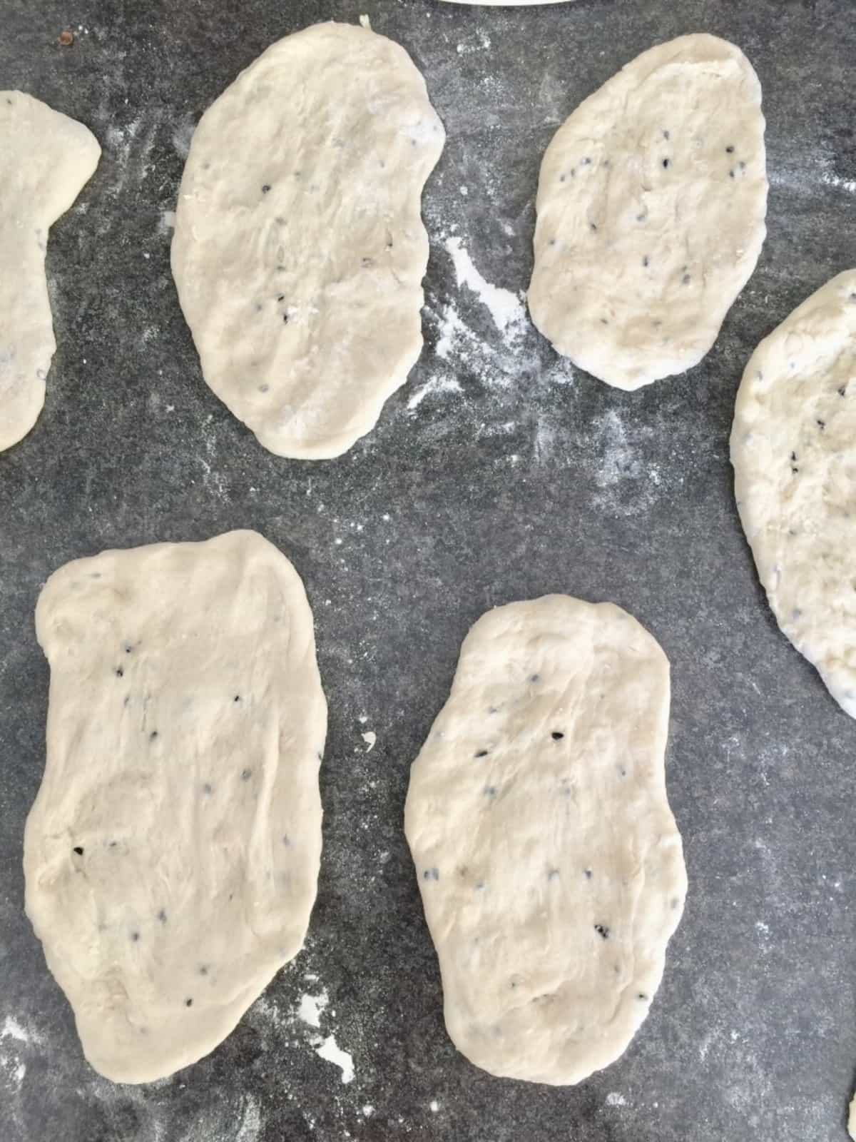 Shaped naan breads on the counter.