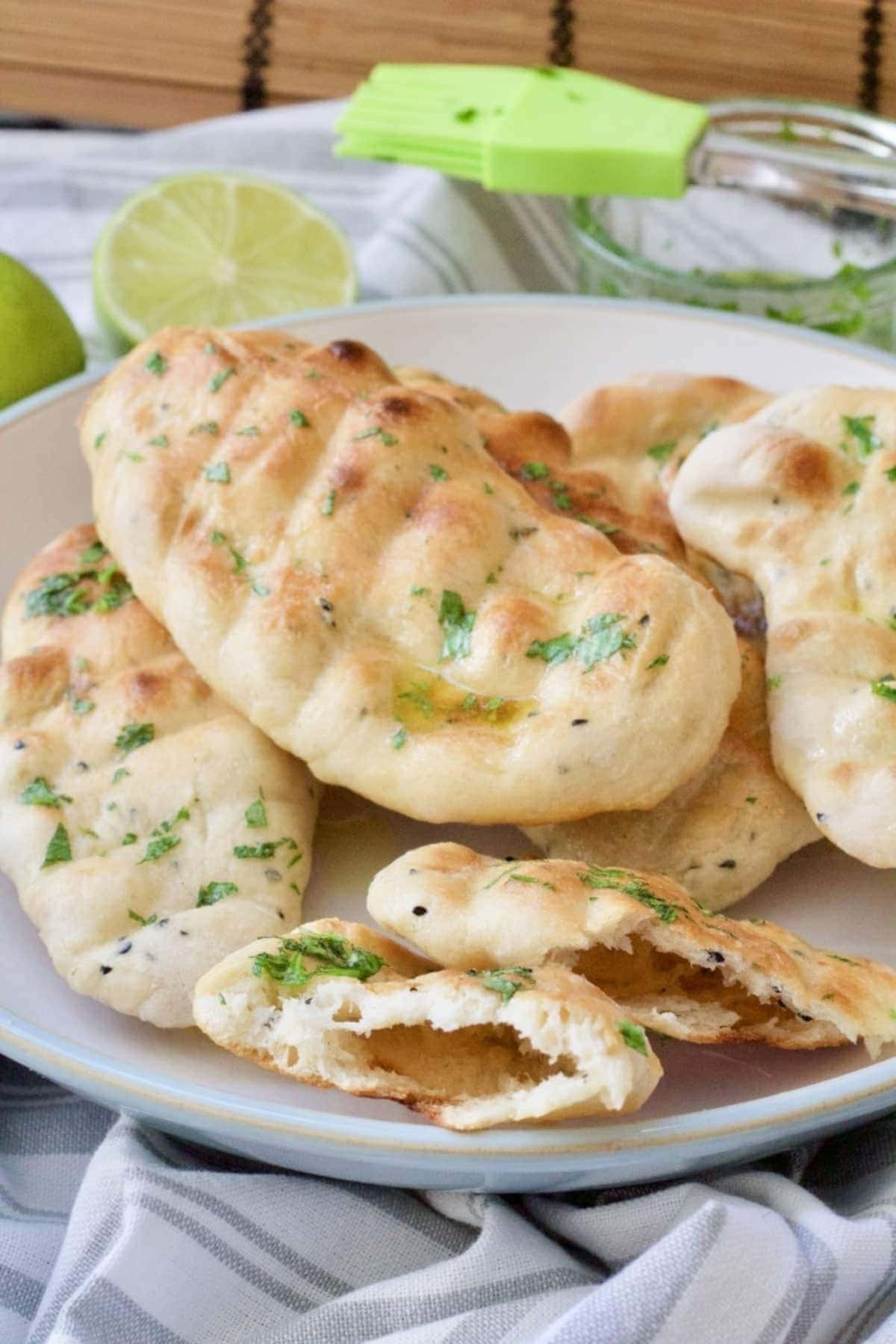 Easy naan bread in a bowl with one cut in half.