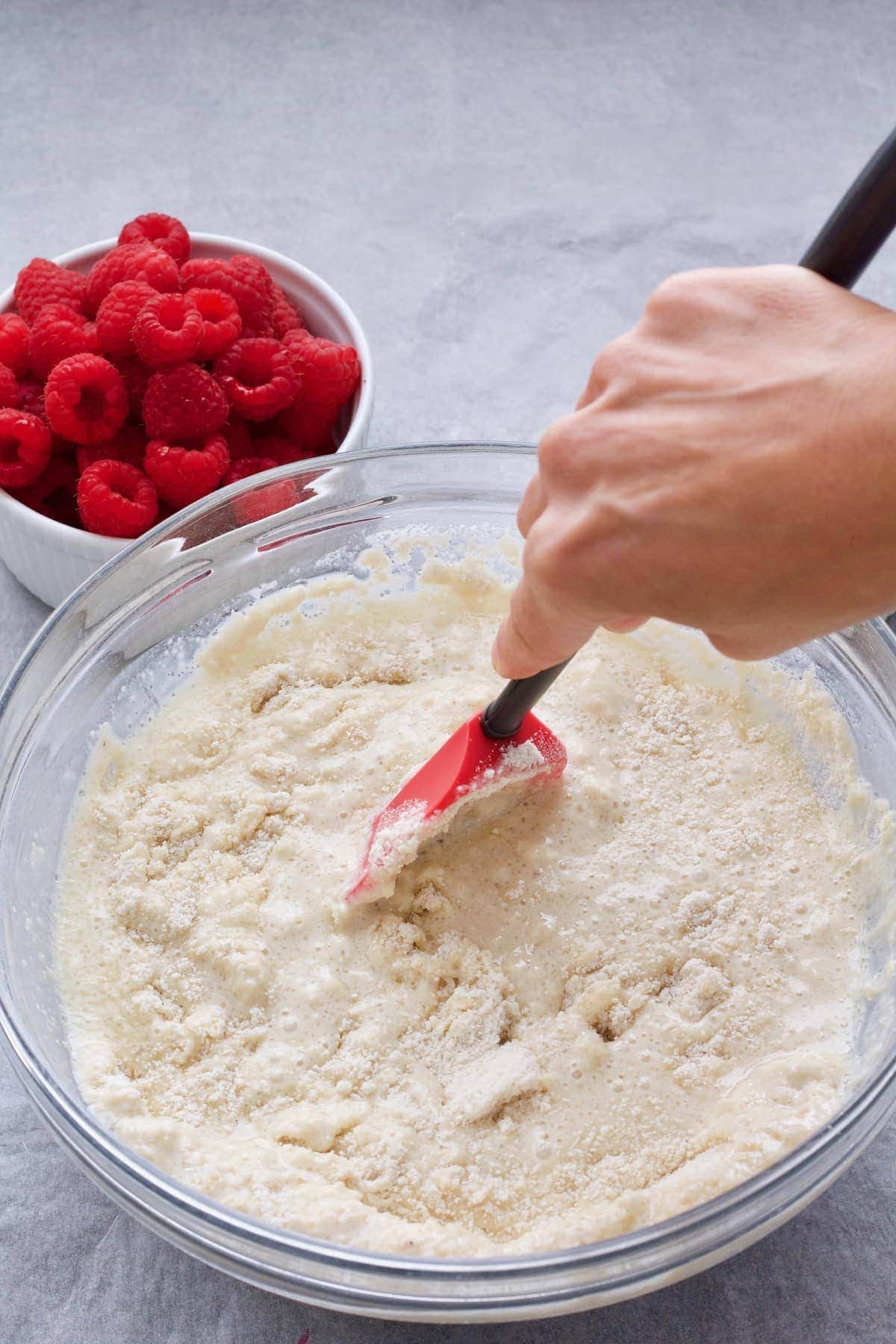 Hand mixing batter with a spatula.