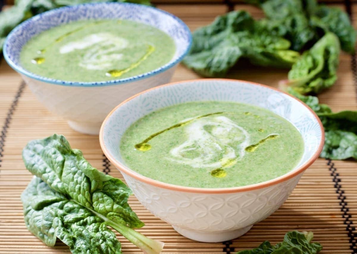 Two small bowls of green soup, landscape view.