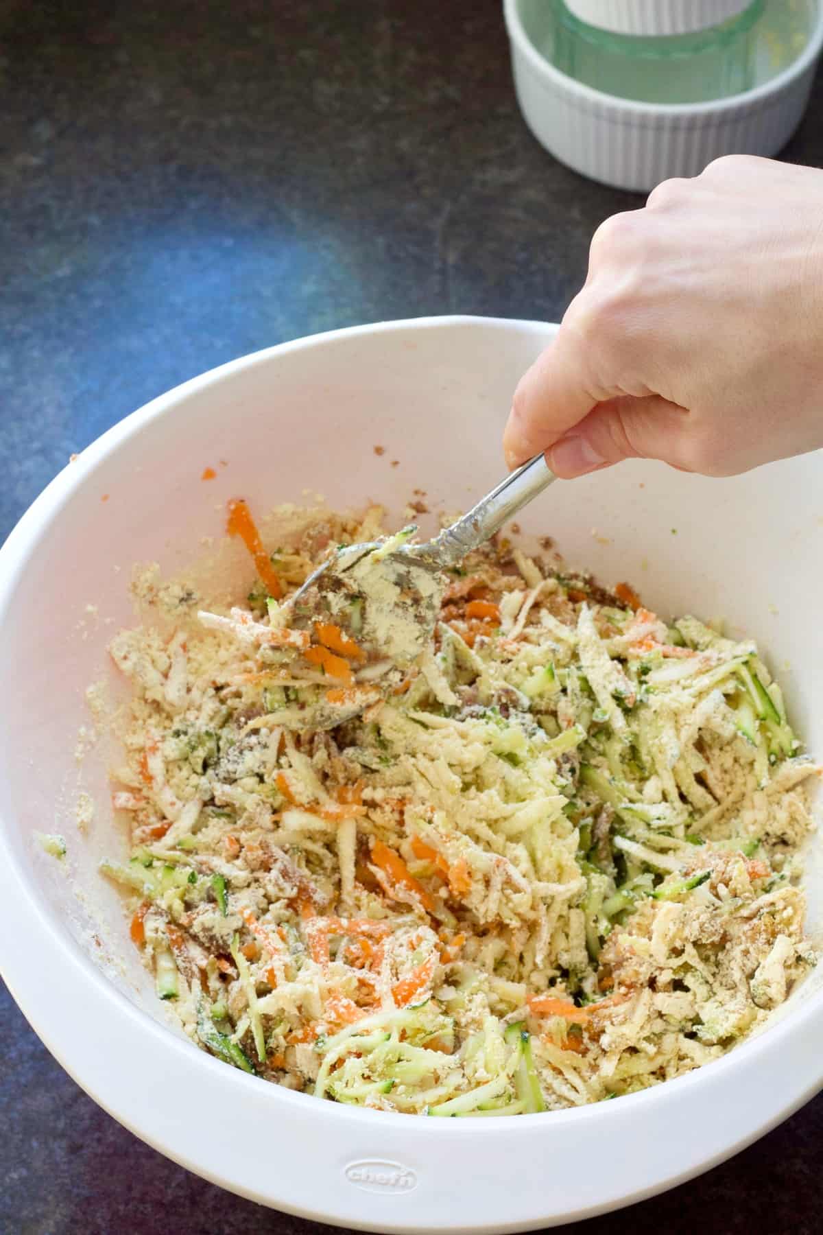 Hand mixing ingredients in a bowl.