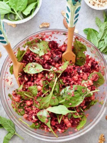 Buckwheat salad presented in a bowl with decorative salad servers.