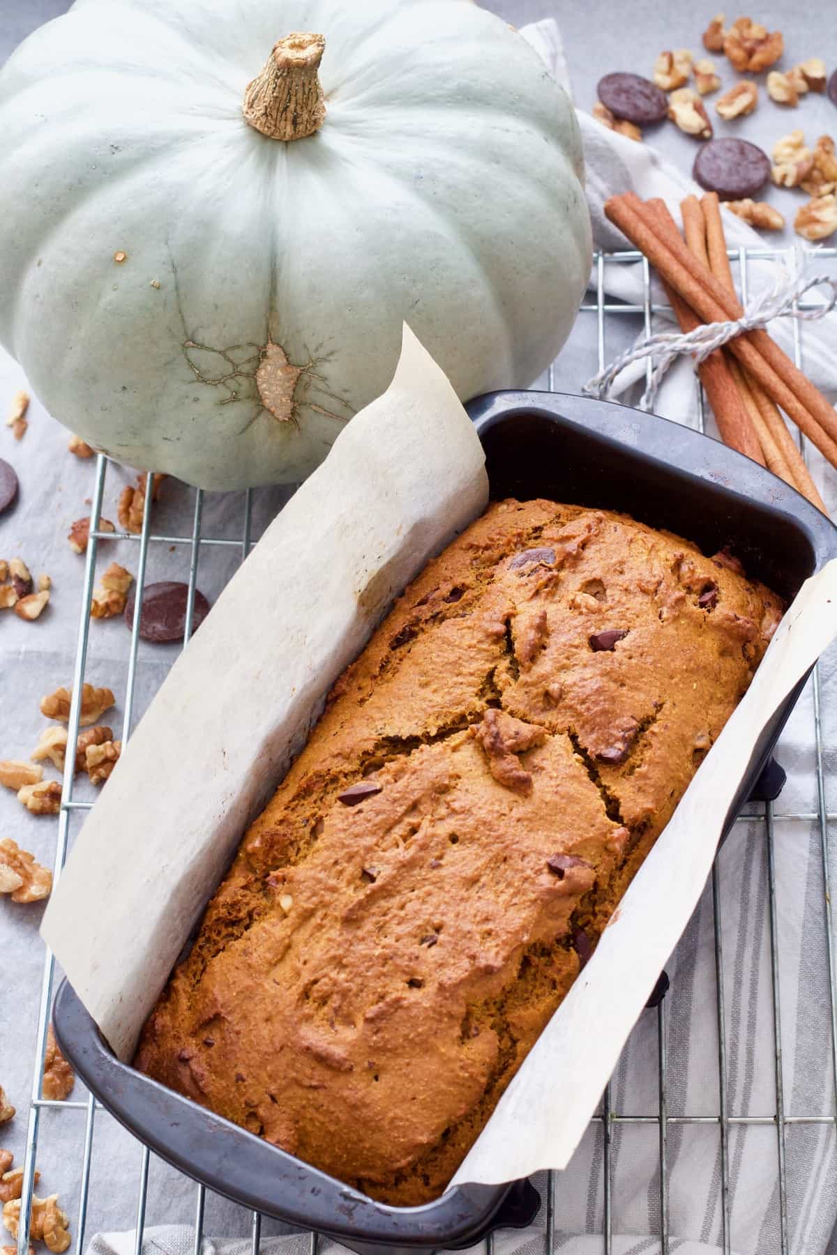 Pumpkin banana bread in a loaf tin on a rack.