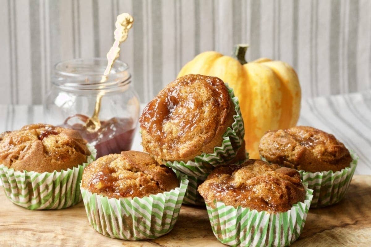 Baked vegan pumpkin muffins on a board.