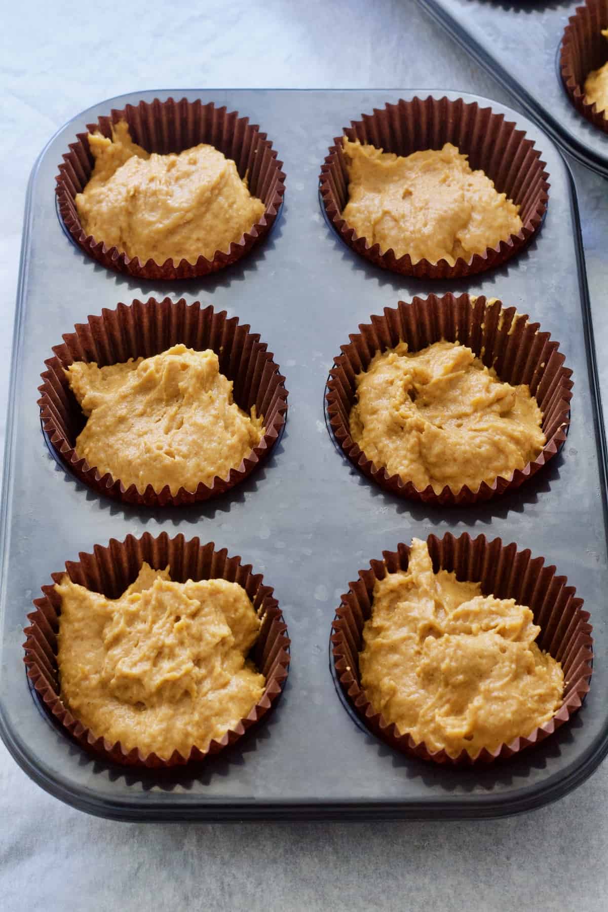 Muffin batter in cases ready for the oven.