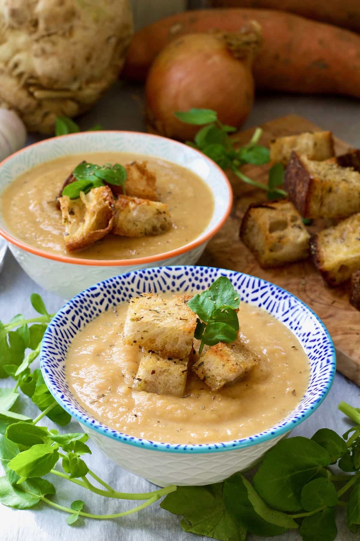 Two bowls of celeriac and sweet potato soup.