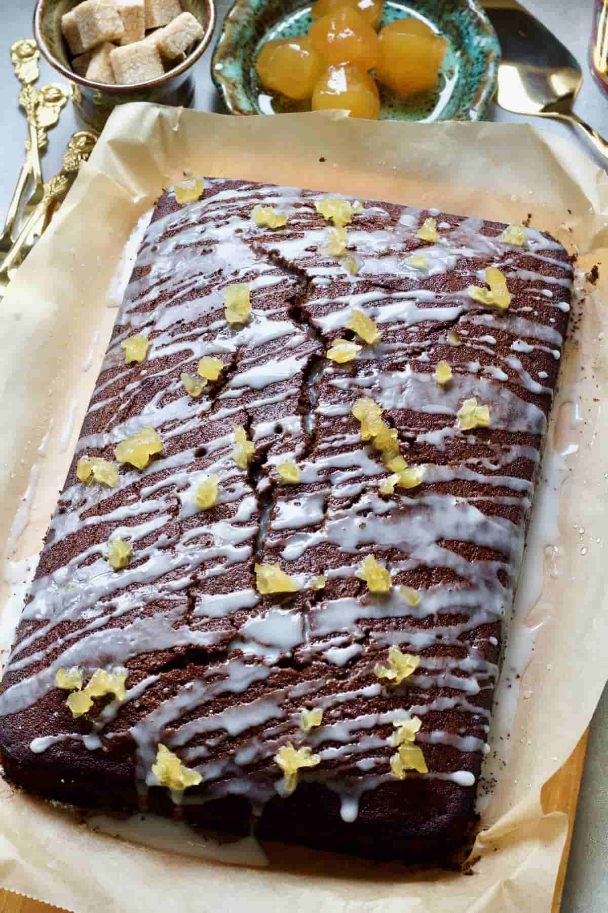 Whole iced gingerbread cake on a baking paper.