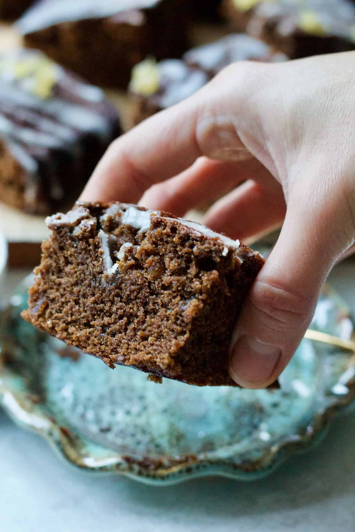 Hand holding slice of cake showing off the crumb.