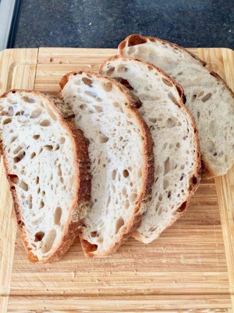 Four slices of bread on a wooden board.