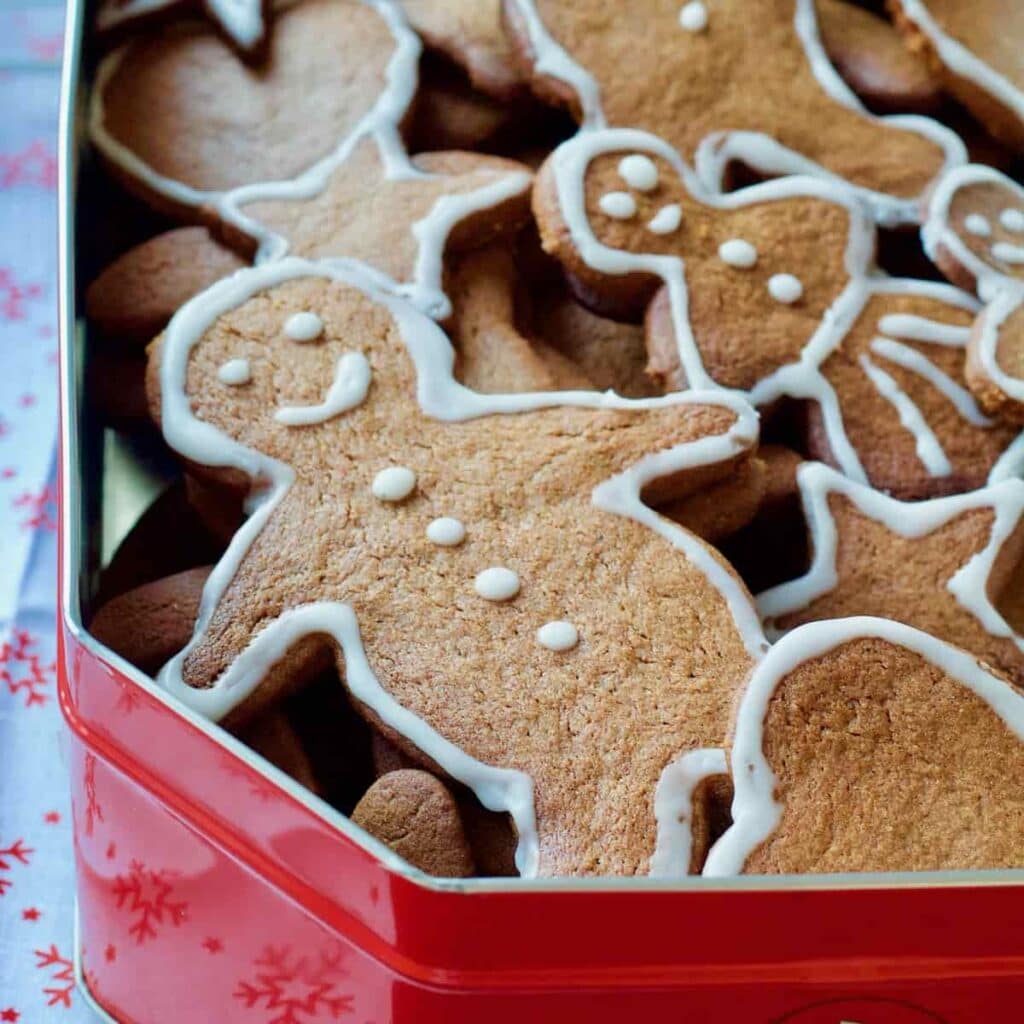 Close up of gingerbread man in a tin with other biscuits.