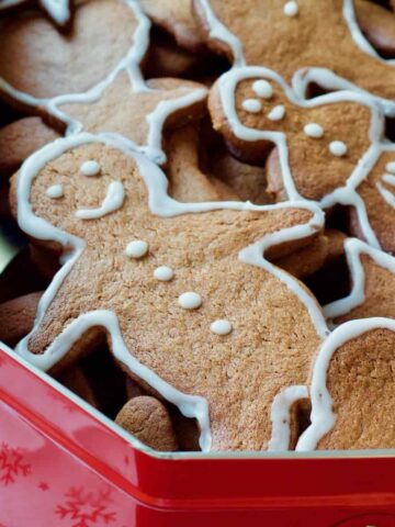Close up of gingerbread man in a tin with other biscuits.
