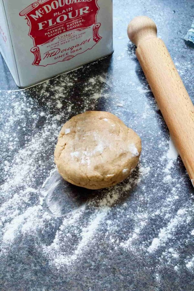 Pastry on a floured counter with a rolling pin.