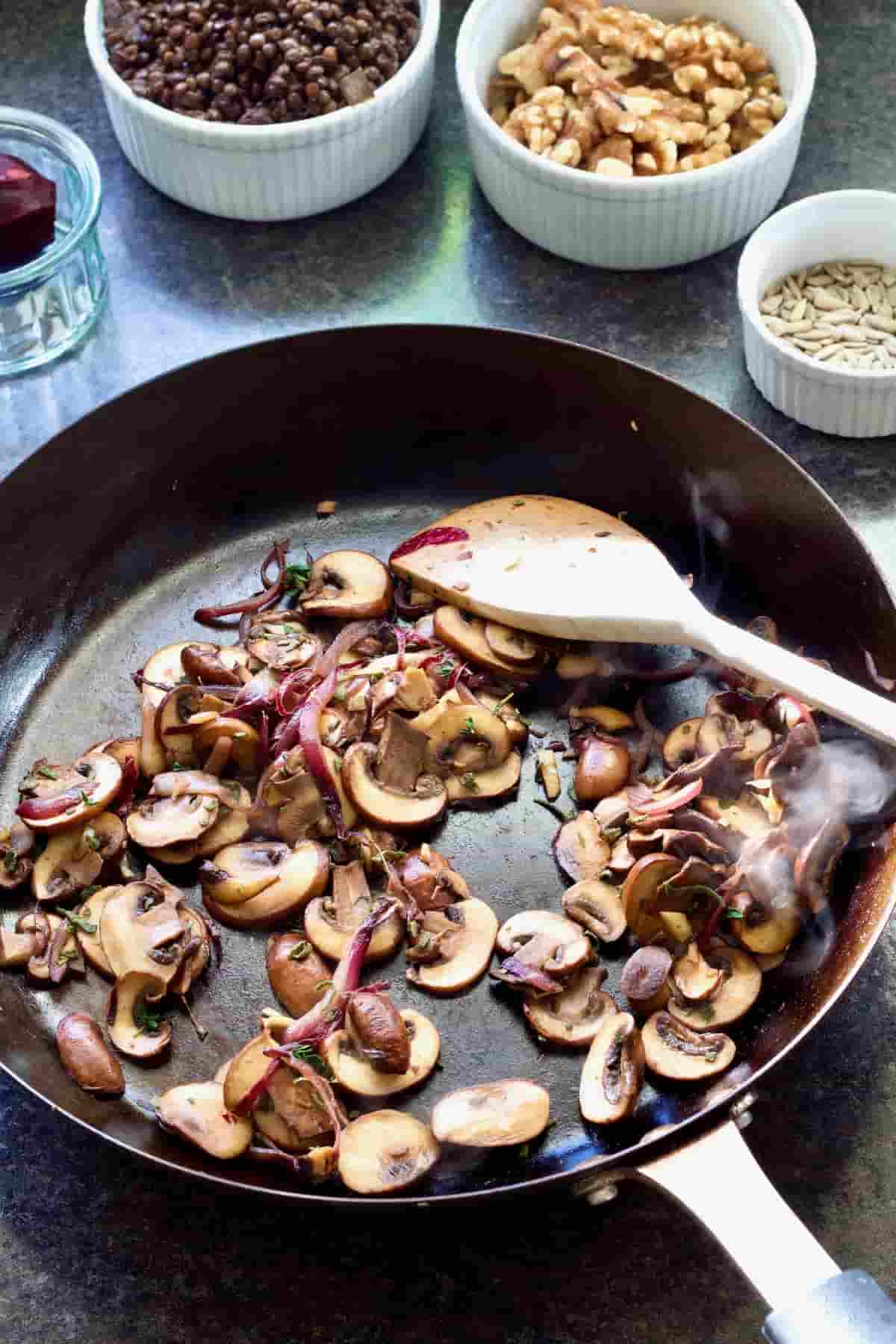Cooked mushrooms and onions in a pan.