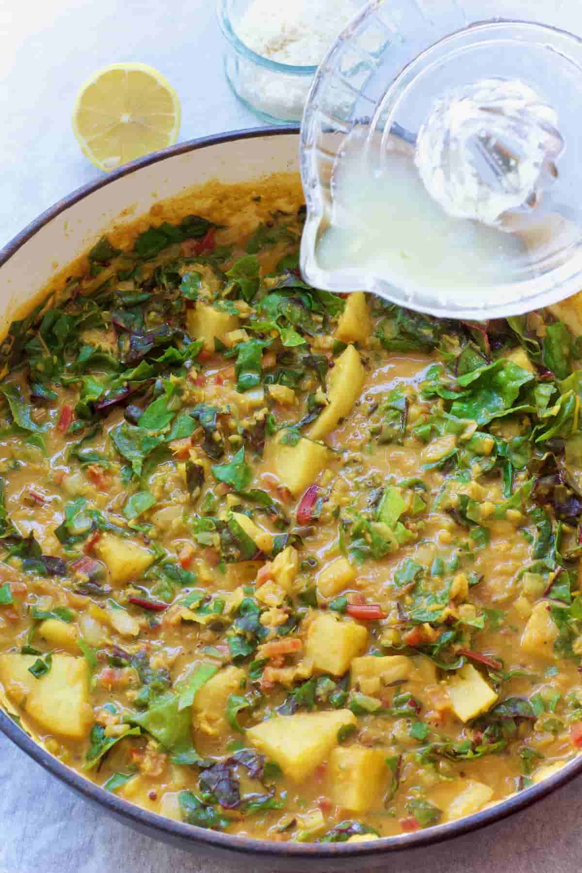 Lemon juice being added to the curry.