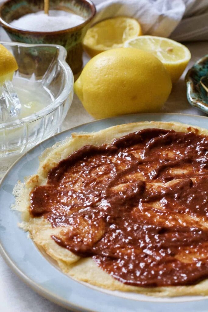 Pancake on a plate topped with chocolate spread.