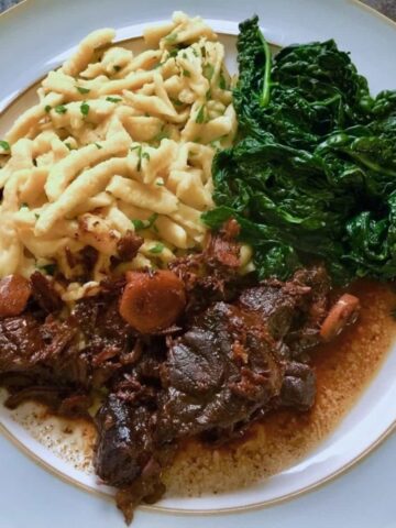 Chinese beef with soy and ginger, noodles and kale on a plate.
