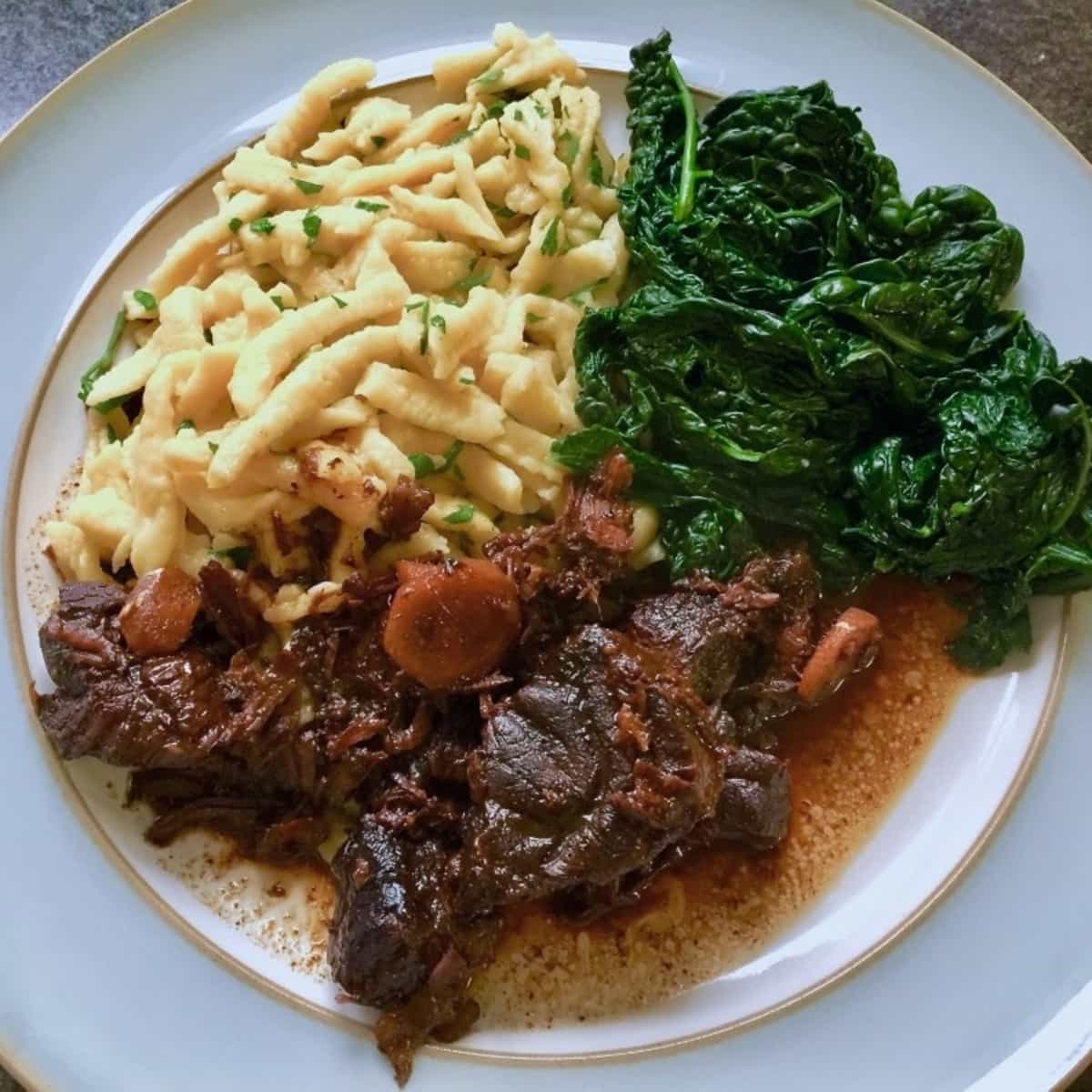 Chinese beef with soy and ginger, noodles and kale on a plate.