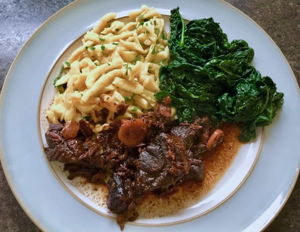 Chinese beef with soy and ginger, noodles and kale on a plate.